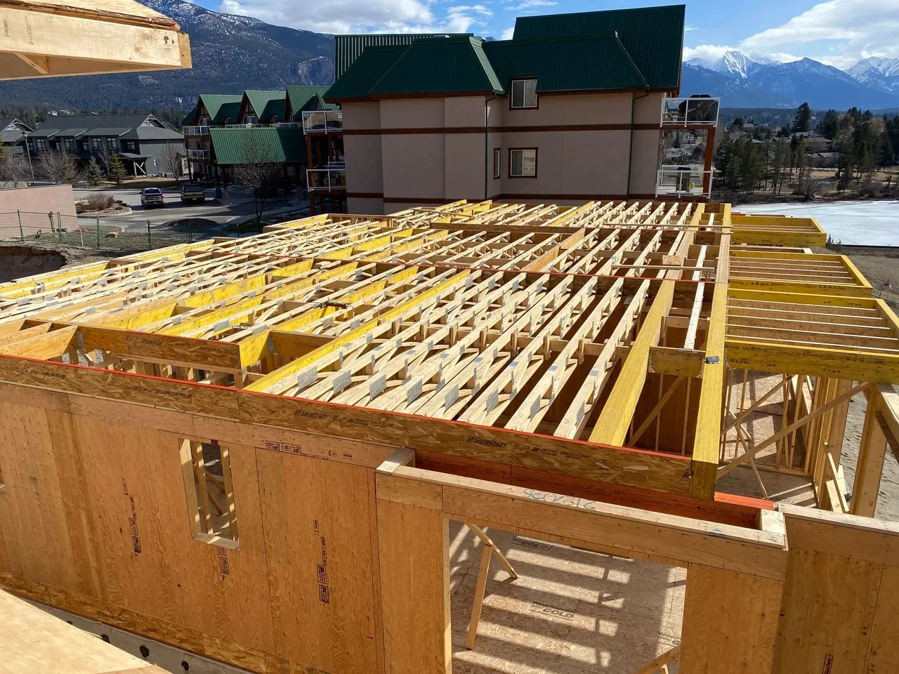 Floor truss framing on a multi-unit building near the Rocky Mountains, built by Sealy Construction