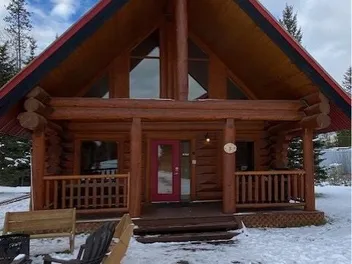 Finished log cabin with new steep-pitch roof near Golden, BC, in winter
