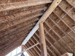 Interior view of the new 12/12-pitch roof framing on the log cabin